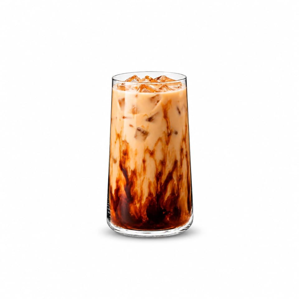 Tall glass of iced coffee with creamy milk and dark syrup swirls against a white background.